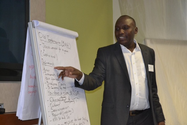 Joel Olloo, a participant from Kenya, gives feedback from his group's breakaway session.